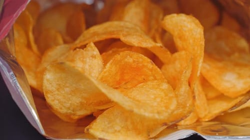 Crispy Fried Potato Chips on a Black Background
