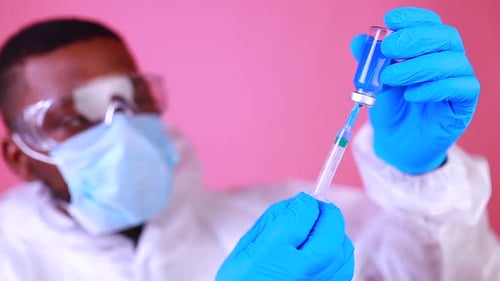Doctor Drawing Blue Liquid into Syringe