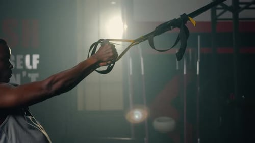 Muskulöser Mann beim Training Training Körpergewicht mit Aufhängegurten TRX