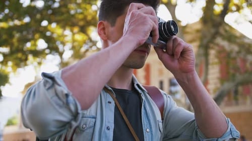 Close Up Shot of Young Attractive Handsome Man Tourist with Backpack Taking Photos on Vintage Camera