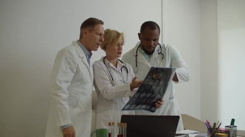 Skillful Diverse Multiracial Physicians Examining Mri Scan of Patient at Medical Clinic