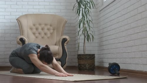 Woman Stretching on Yoga Mat in Living Room