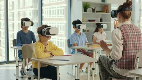 Multicultural School Children Using Virtual Reality Headsets in Classroom with Teacher