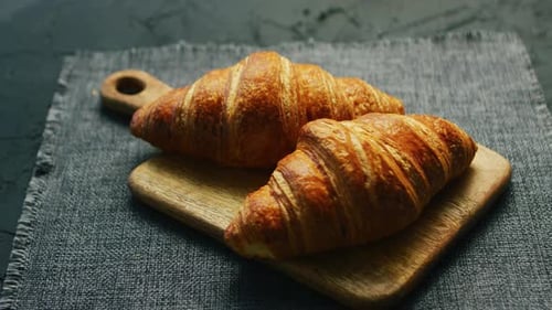 Fresh Golden Croissants on a Wooden Board