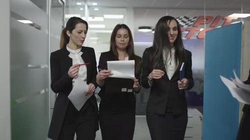 Businesswomen Walking and Talking in Modern Office