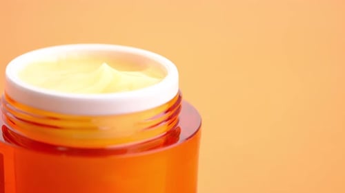 Close Up of Face Cream in a Orange Container