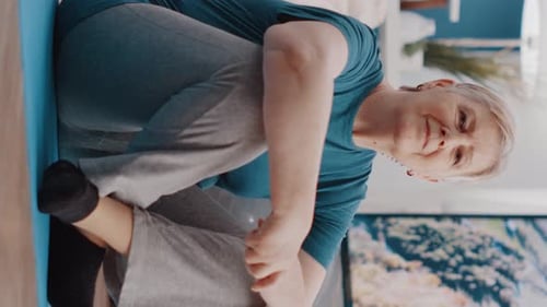 Senior Woman Stretching Leg on Yoga Mat