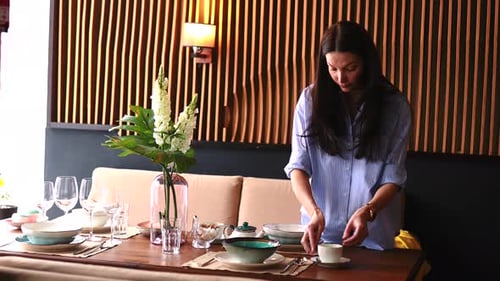 Woman Setting a Dining Table in a Home