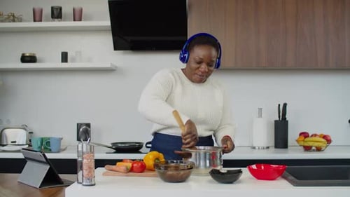 Woman Cooking and Dancing in Kitchen With Headphones