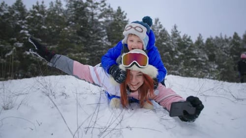 Mother and Child Playfully Sledding in the Snow