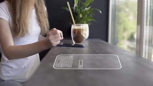 Video where a girl is typing a message on the phone while in a cafe while drinking a cocktail