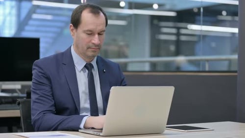 Businessman Working on Laptop in Office