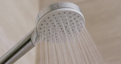 Shower Head Sprays Water in Modern Bathroom