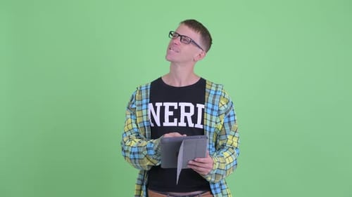 Young Adult Using Tablet Against Green Screen