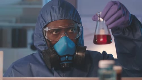 Scientist Examining Red Liquid in Laboratory