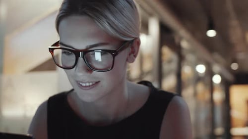 Woman Smiles Using Device in Office Workplace
