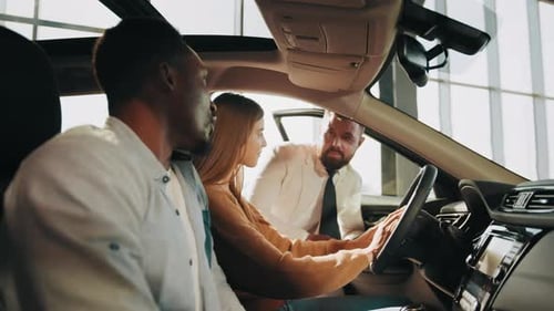 Young Adults Inspecting Car in Dealership