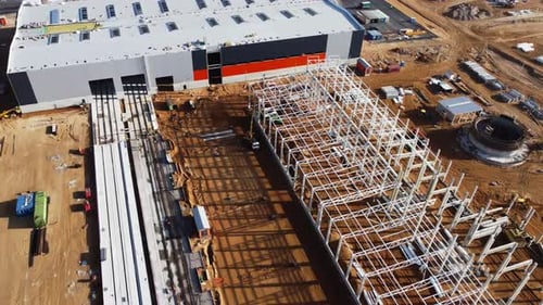 Aerial Drone Shot of a New Constructions Development Site Warehouses Projects and Heavy Machinery