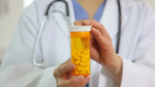 Doctor holds up bottle of pills