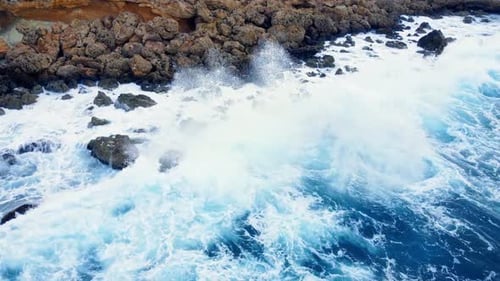Ocean Coastline Cliffside with Blue Pure Water Sea Waves Washes the Rocky Shore Above Aerial Shot