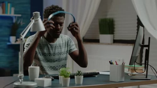 Man Working at Computer With Headphones at Home