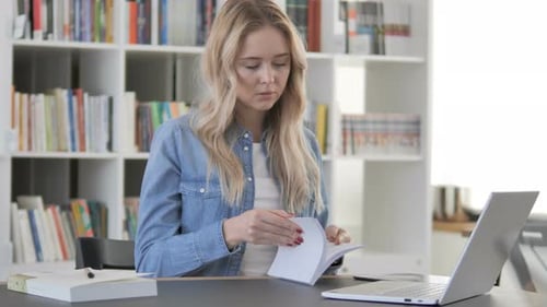 Young Woman Reading Book in Library