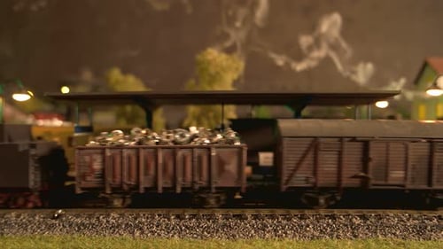 Model Train with Freight Cars Passing Through Station