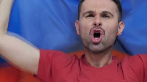 Man Yelling with Flag in the Background