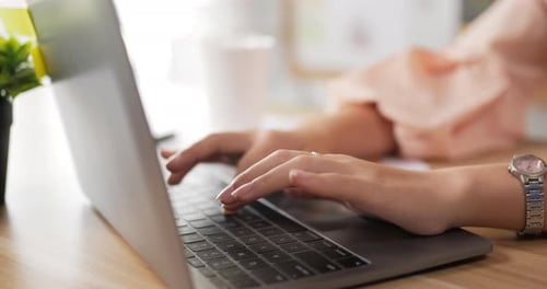 Close up side view of Female hands typing on laptop