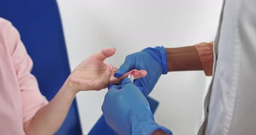 Doctor Taking Finger Blood Sample for Testing