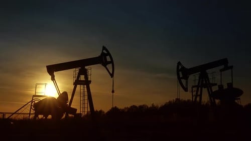 Silhouette of Pump Jacks Operating at Sunrise