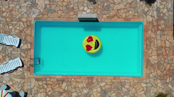 Icono de emoji de sonrisa flotando en la piscina en el campo ...