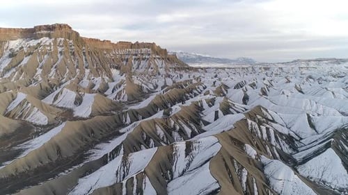 Flying fast over the rugged terrain in the desert covered in snow