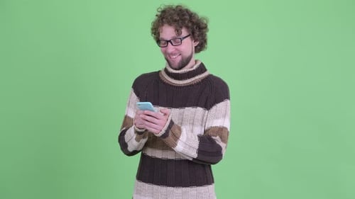 Young Adult Using Cell Phone With Green Background