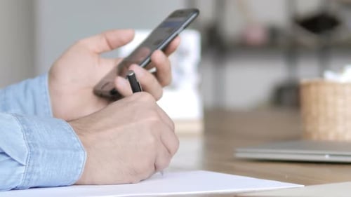 Smartphone benutzen und bei der Arbeit schreiben