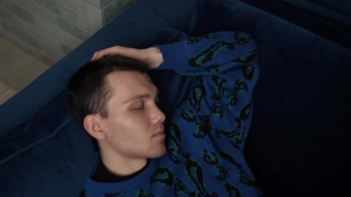 Man Resting Quietly on a Blue Couch