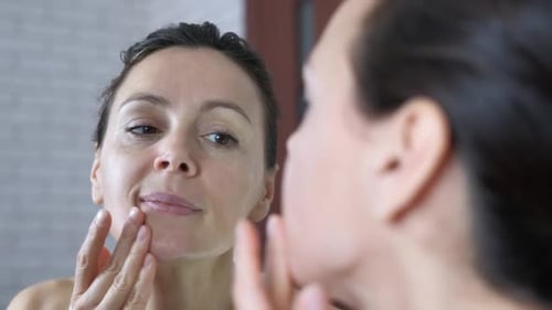 Woman Applies Moisturizer to Her Face