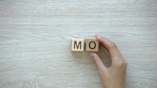 No Money Hand Putting Words on Wooden Cubes in Material Need Loss and Damage