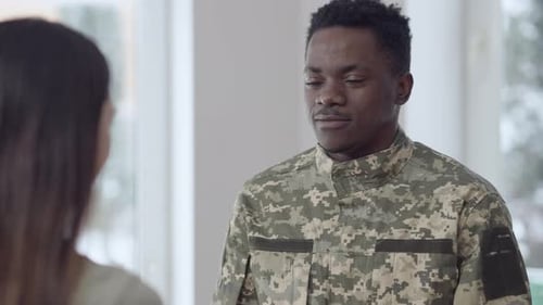 Soldier Embraces Woman Indoors