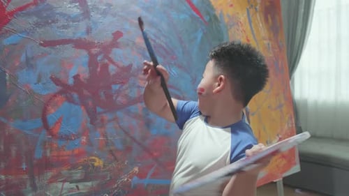 Enthusiastic Boy Painting Colorful Abstract Art Indoors