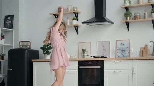 Young Woman Dances in Kitchen with White Cabinets