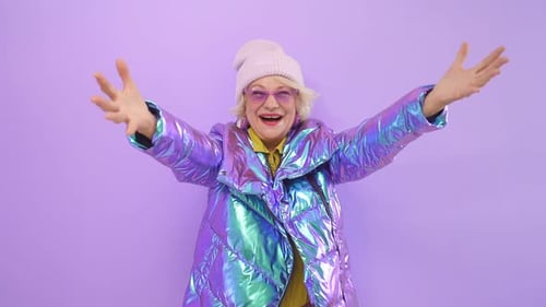 Senior Woman Gesturing Energetically in Front of Wall