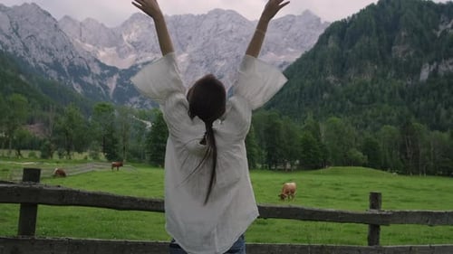 Girl Enjoying Countryside Landscape with Alps and Cows