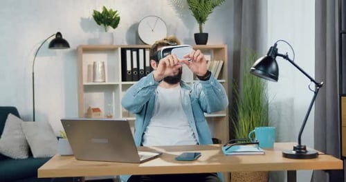 Man Using Virtual Reality Headset at Desk