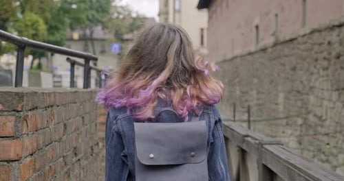 Teenager Girl Walking Across Vintage Wooden Bridge in Old Tourist Town, Back View