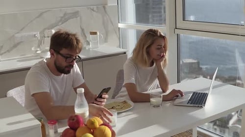 Couple Working at Home Kitchen Table with View