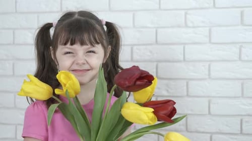 Happy Child Holding a Tulip Bouquet Indoors