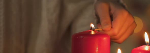 Girl Lighting Candle, Looking at Flame, Concept of Fire Safety at Christmas