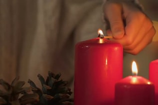 Girl Lighting Candle, Looking at Flame, Concept of Fire Safety at Christmas