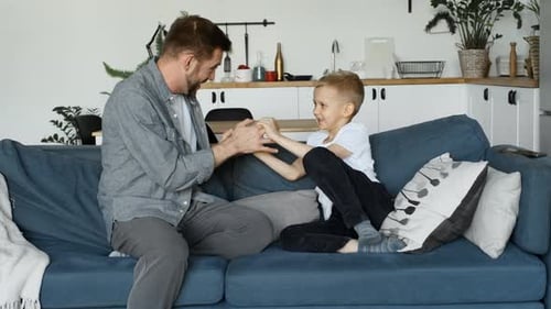 Father and Son Playing Together on Couch